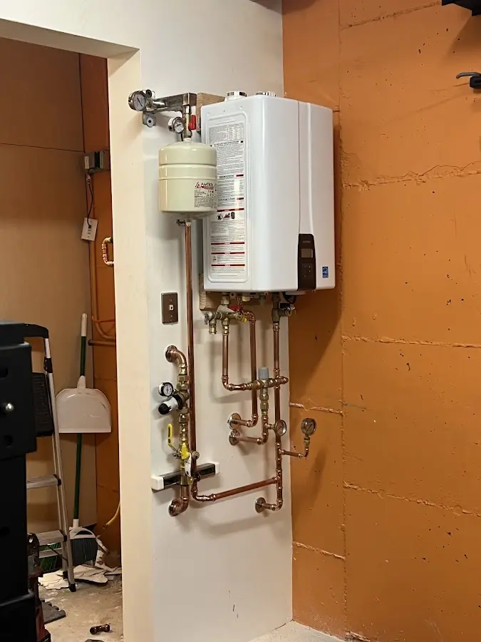 Plumbing technician inspecting water heater connections in Richton Park